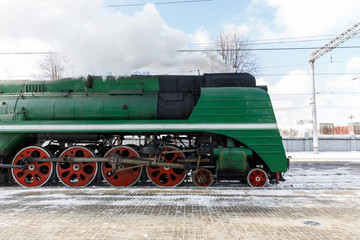 Fototapeta na wymiar old black steam locomotive in Russia in the winter on the background of the Moscow railway station