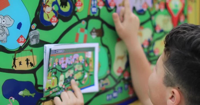 Portrait of a child looking and pointing at destination on large map