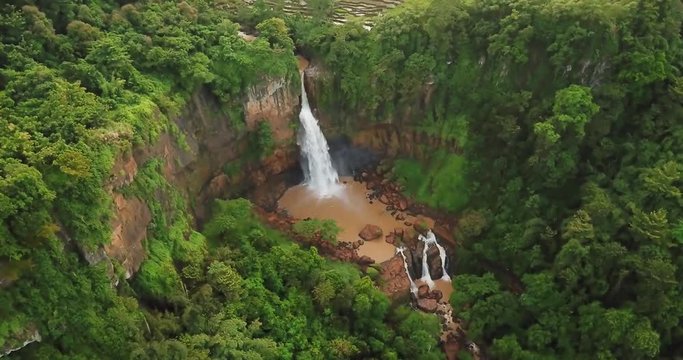 Beautiful aerial footage of Cimarinjung waterfall with green trees at Ciletuh Geopark, Sukabumi, West Java, Indonesia. Shot in 4k resolution