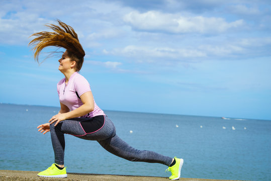 Woman doing yoga next to sea