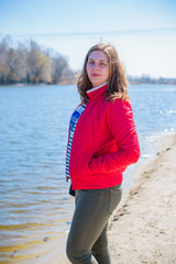 A woman of plus size, American or European appearance walks at nature enjoying life. A young lady with excess weight, in sport dress. Natural beauty 