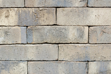 Wall of an old uneven brown brick. background