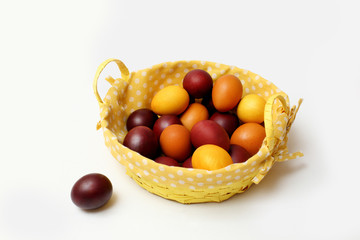 red and yellow Easter eggs in basket on white background