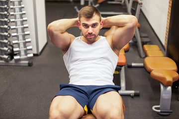 Fototapeta na wymiar sport, fitness, bodybuilding, lifestyle and people concept - young man doing sit-up abdominal exercises Bench Press in gym