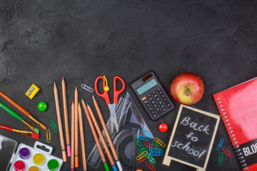 School supplies on black board background colorful back to school
