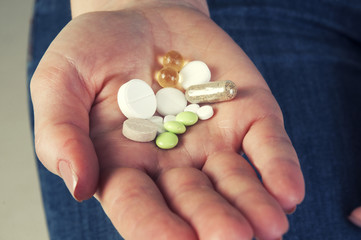 Multicolor pills in your palm, medications in woman's hand