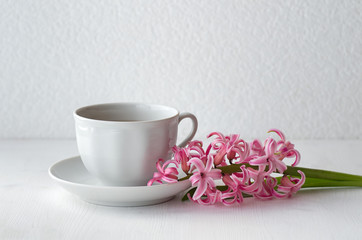 Green tea in a white mug. hyacinth flower on white table