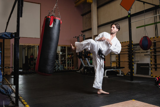 Man practicing karate with punching bag