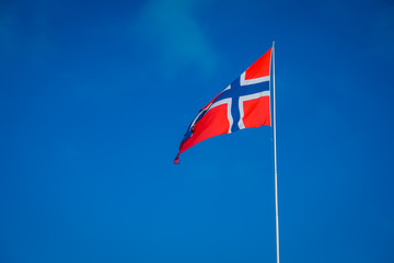 Outdoor view of Norwegian flag with a beautiful blue sky