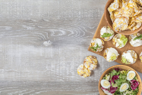 Delicious, nutritious cereal breads with cream cheese on kitchen table among some kitchen items.