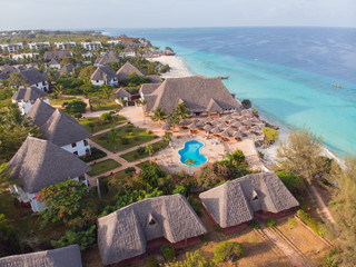 Aerial view of a beautiful tropical island and beach, small fisherman boat on clear blue reef water along Africa, Tanzania, Zanzibar. Indian Ocean