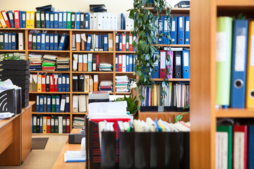 A lot of paper documents arranged with colourful file binders, data centre