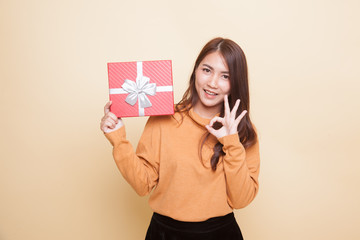 Young Asian woman show OK with a gift box.