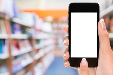 Hand holding phone on blurred background