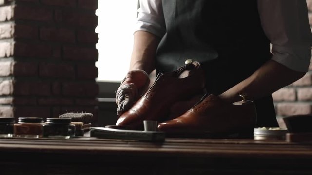 Shoe shop. Shoes master polishes boots