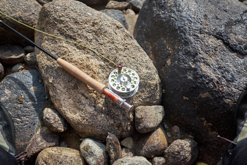 Fly fishing rod and reel lying on a rock
