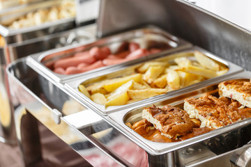 Buffet trays heated ready for service. Breakfast in hotel smorgasbord. Plates with different food