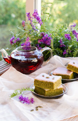 Matcha green tea cakes with white chocolate glaze seeds with tea on the white background