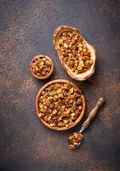 Raisins in wooden bowl on rusty background