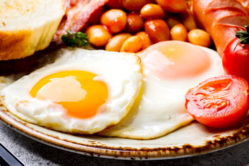 Traditional English Breakfast Food on stone Eggs ,Sausages, Bacon, Beans,Toasts