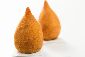 Coxinha is a deep fried food, traditional in Brazil. Two snacks on white background. Selective focus, minimalism.