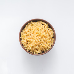 Spiral pasta in bowl on white background, top view