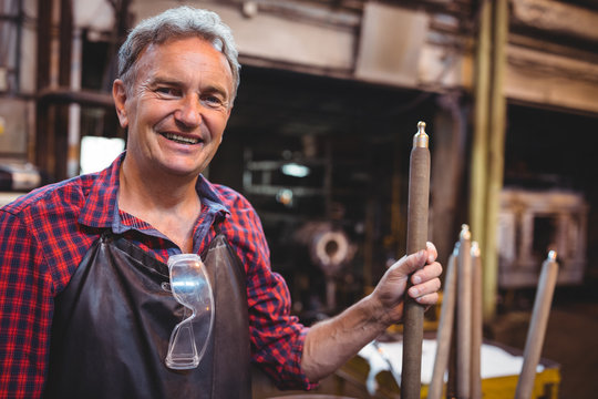 Portrait of glassblower holding blowpipe