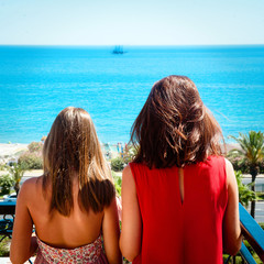 Mother and daughter looking on the sea