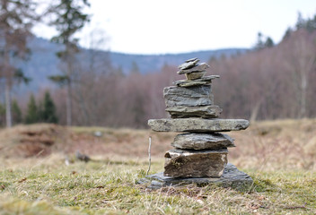 Cairn marking a hiking trail in a clearing in the forest