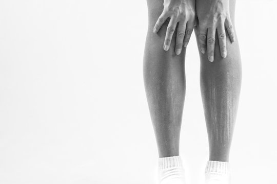 dry skin on the legs, itching of the legs, a person suffers from itching on his legs in consequence of dry skin.black and white image with free space for text