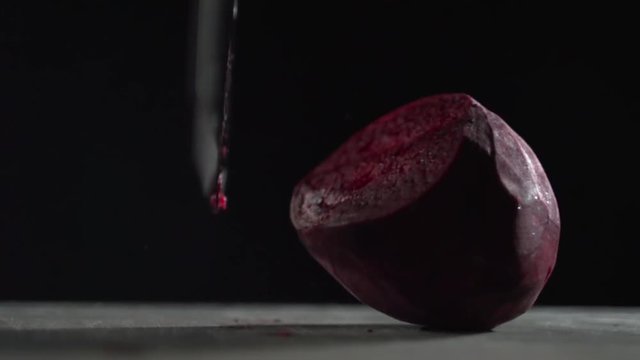A sharp blade cuts the beet into pieces.