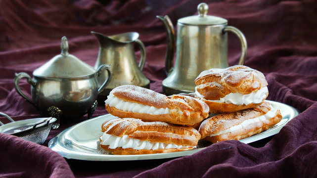 Eclairs, Choux Pastries Filled With Whipped Cream, Dark Violet Background, Silver Dinnerware