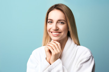 Beautiful young woman with silky skin on color background