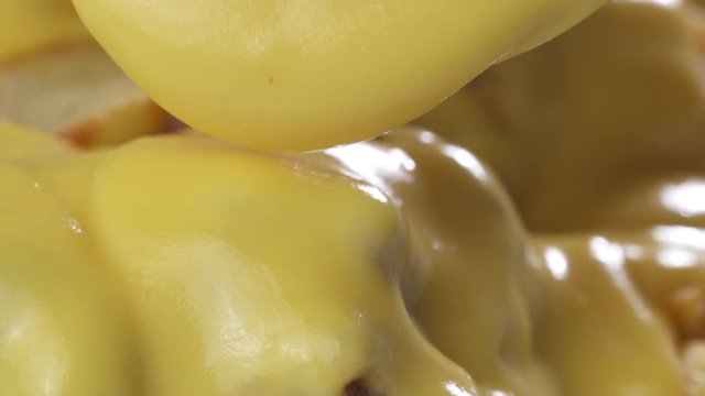 Macro closeup chef putting melted cheese on top of the french fries chips with chilli con carne sauce - video in slow motion