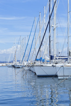 Rows of sailing boats in a small Mediterranean sea port .