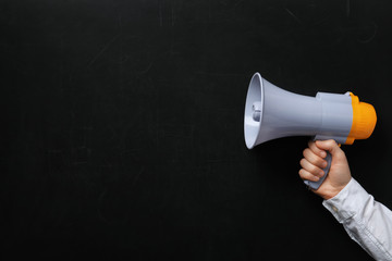 Man holding megaphone near chalkboard