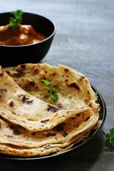 Homemade layered Paratha / Parotta or Indian flat bread with Paneer curry
