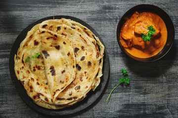 Homemade Kerala wheat paratha or layered  parotta  served with Paneer curry, top view