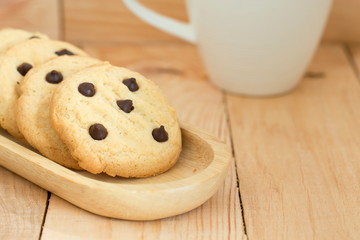 chocolate chip cookies on wooden plate.
