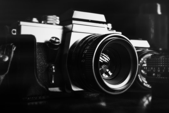 Black and white image of vintage film cameras and lenses