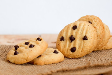 Pile of chocolate chip cookies on wooden table.