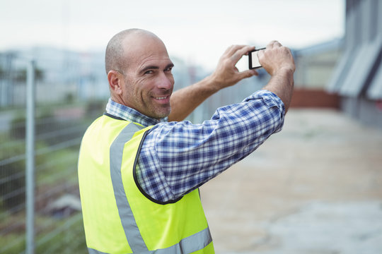 Construction worker photographing with a mobile phone