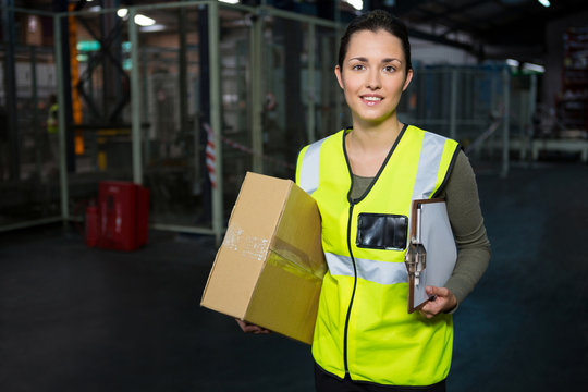 Portrait of young female worker standing in warehouse