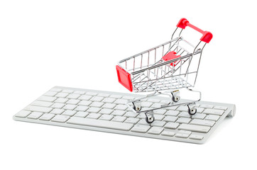 Shopping cart on white keyboard and graph show break even point, concept business