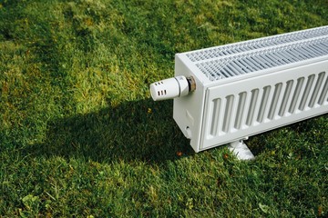 radiator on green lawn, ecological heating concept