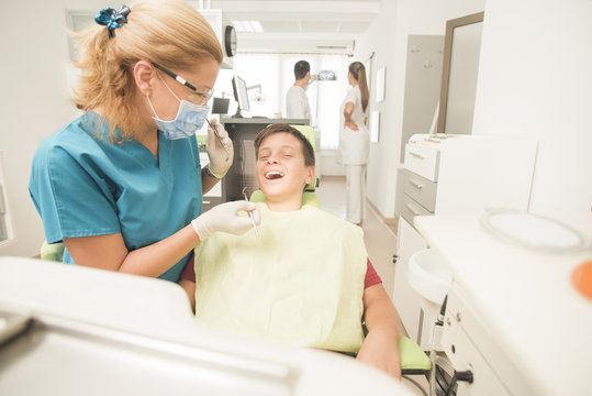 Young teenager is terrified at the dentist with the clinic at the background - oral hygiene health care concept