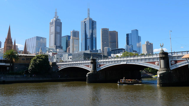 Melbourne, Australia. Skyscrapers and the bridge over the Yarra river. Boat passes through the Princes Bridge © guliveris