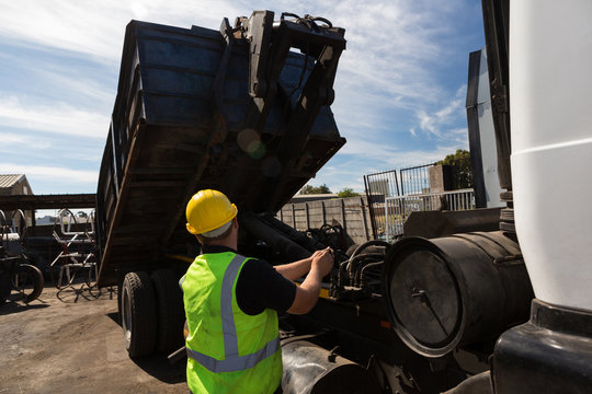 Worker lifting the container of a dumper truck