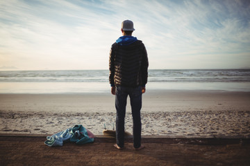 Man with surfboard standing on beach