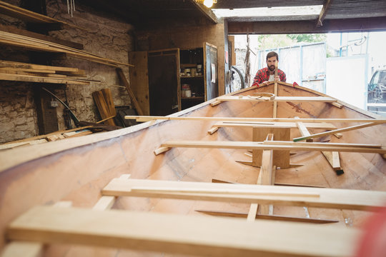 Man preparing wooden boat frame